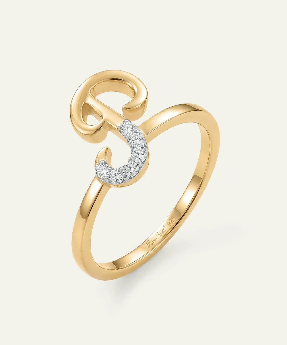 Gold ring with a diamond crescent moon design on a light gray background