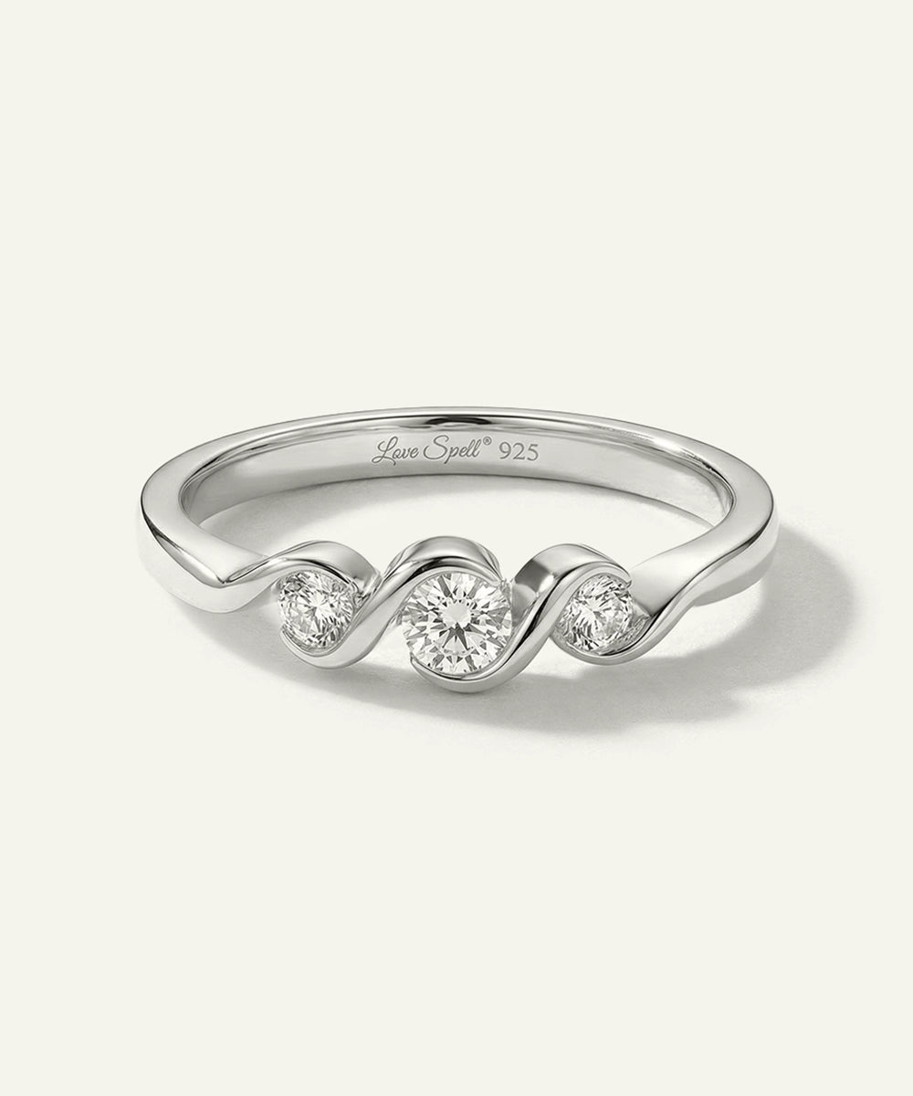 Silver ring with wavy design and embedded diamonds on a white background