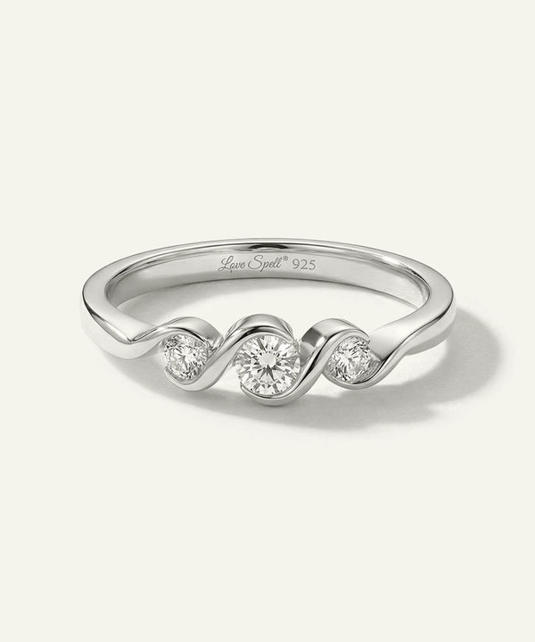 Silver ring with wavy design and embedded diamonds on a white background