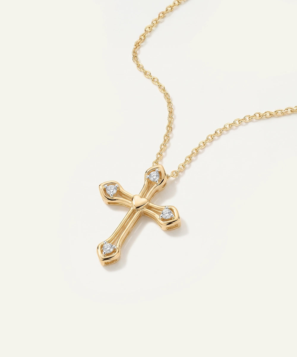 Gold cross necklace with diamonds on a white background