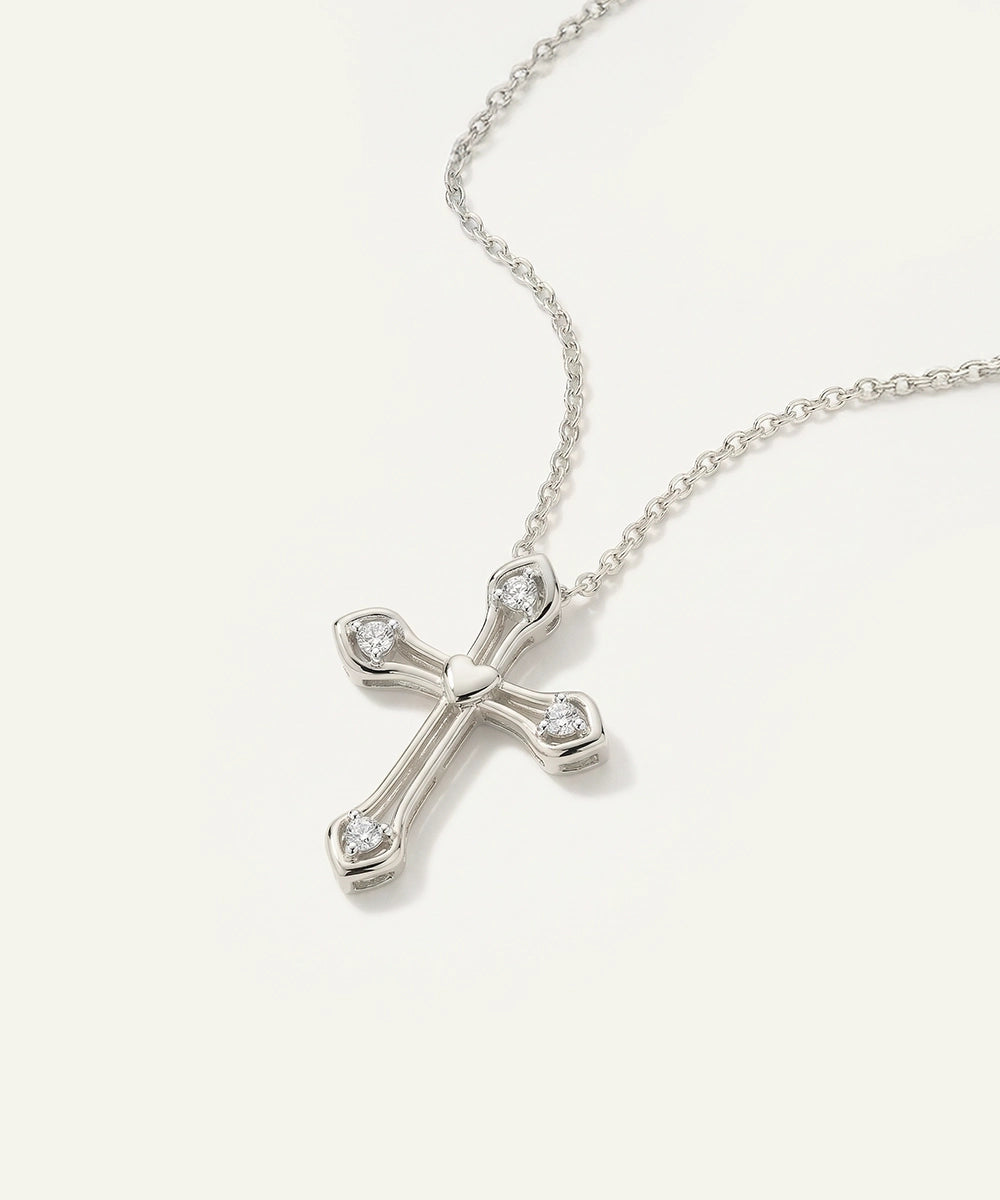 Silver cross necklace with clear stones on a white background