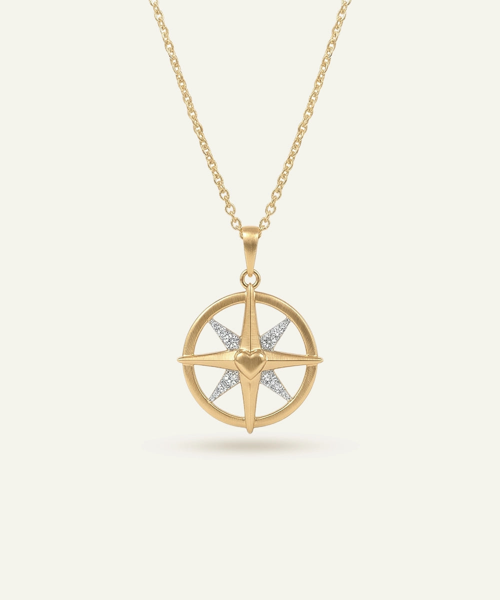 Gold necklace with a star-shaped pendant on a light beige background