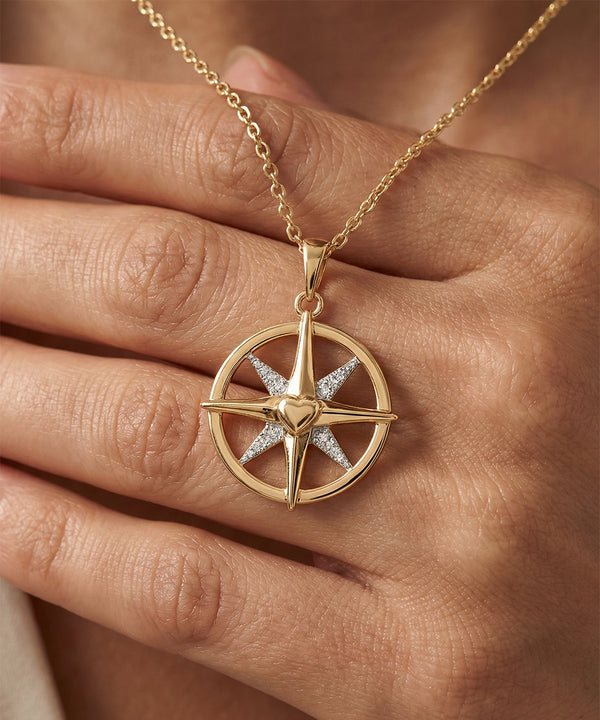 Gold necklace with a star-shaped pendant on a hand