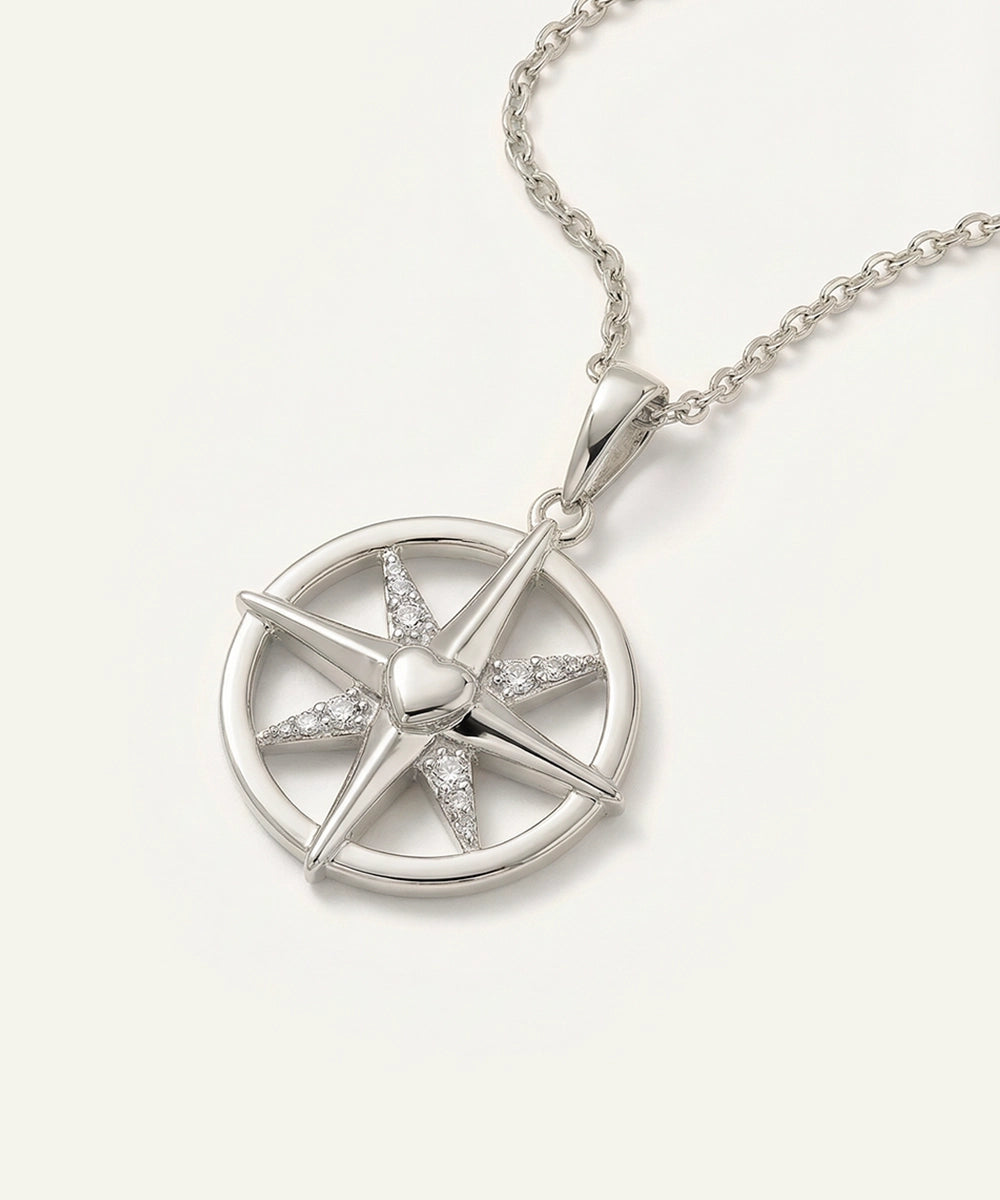 Silver necklace with a star-shaped pendant on a light gray background