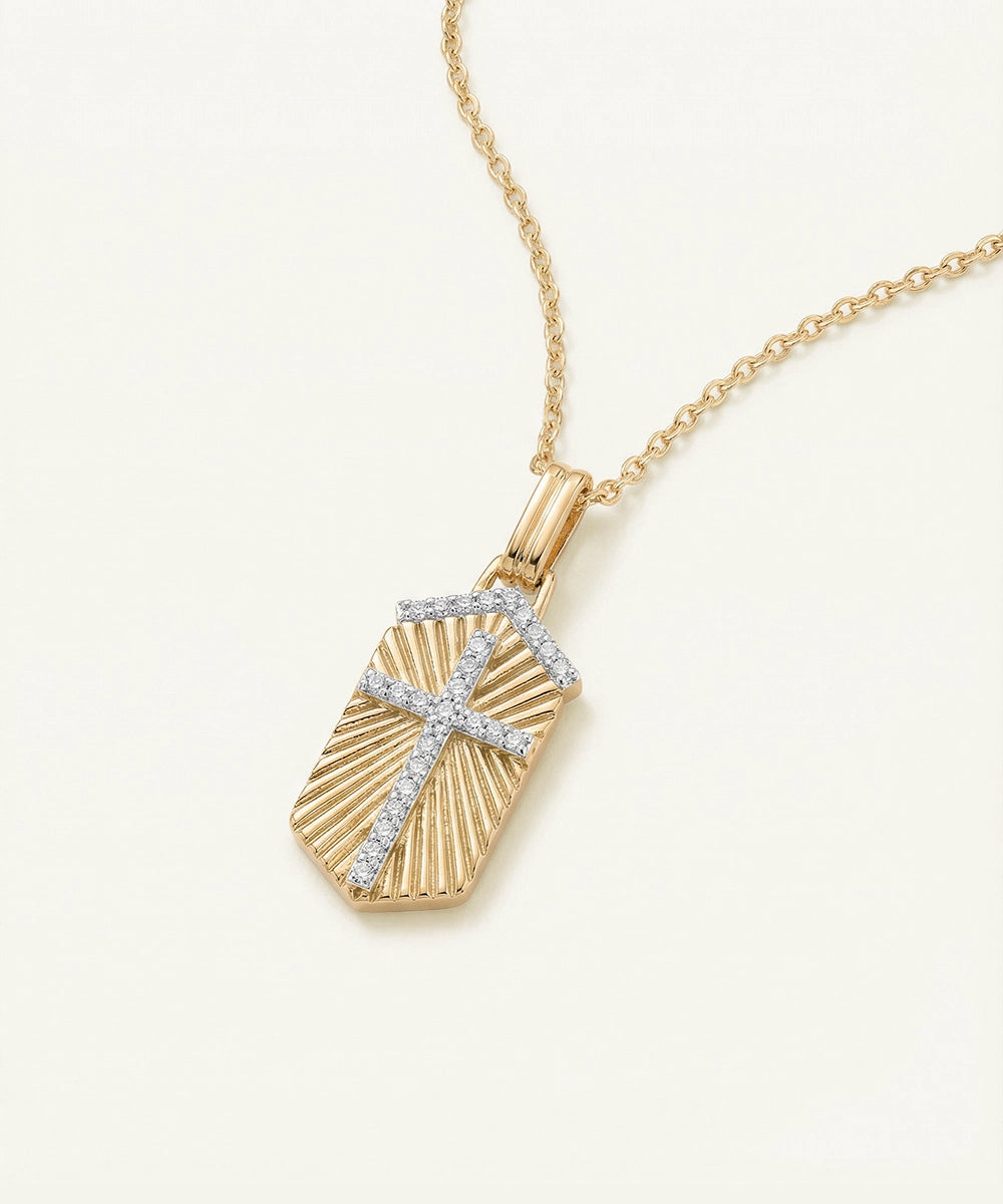 Gold necklace with a pendant featuring a cross design on a white background