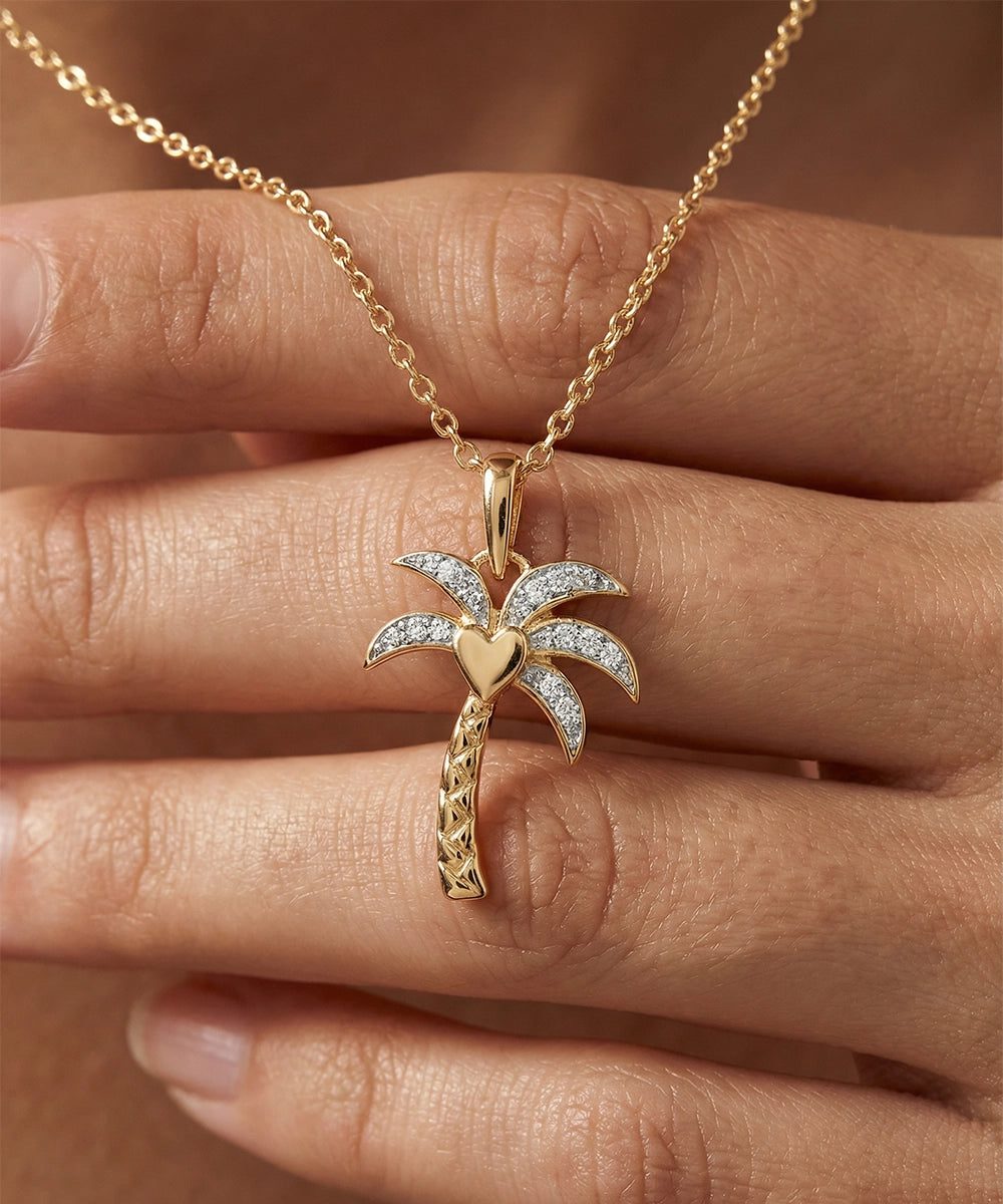 Gold palm tree necklace with diamonds on a hand