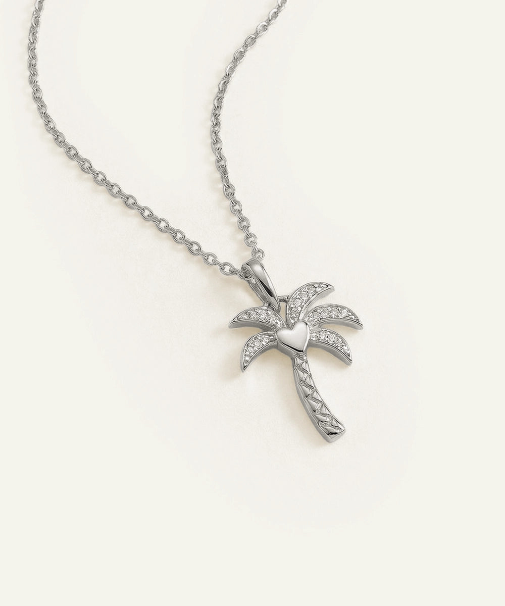 Silver palm tree necklace on a white background