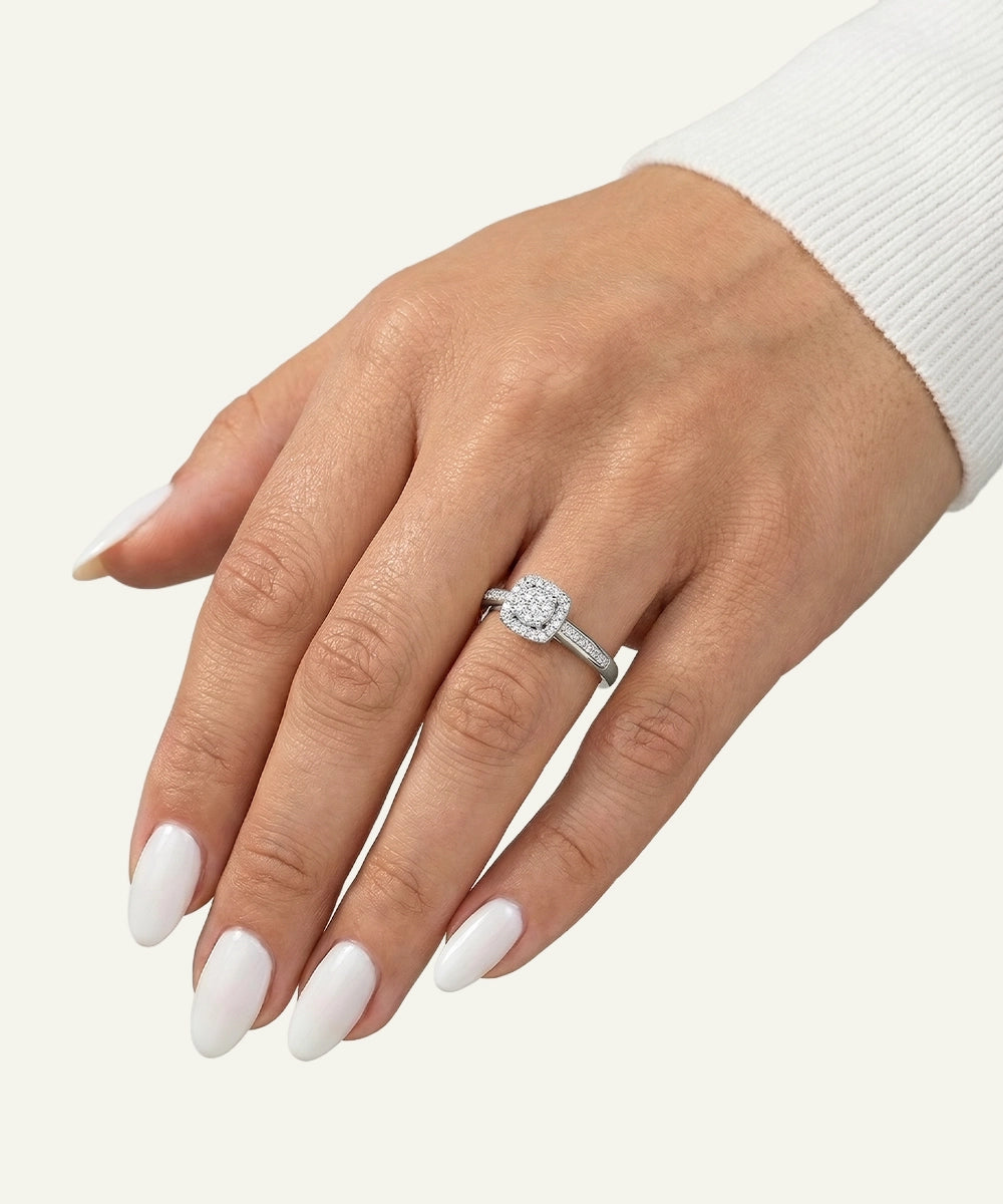 Hand wearing a diamond ring on a white background