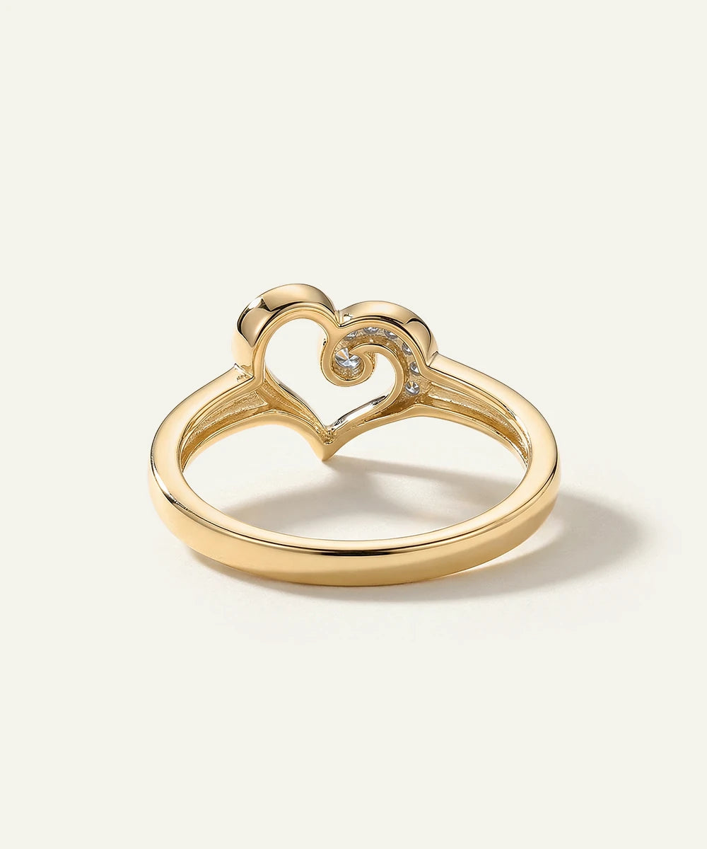 Gold heart-shaped ring with diamonds on a white background