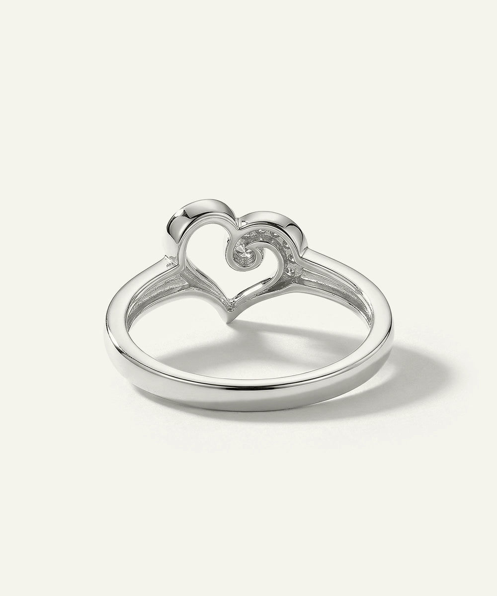 Silver ring with a heart design on a white background