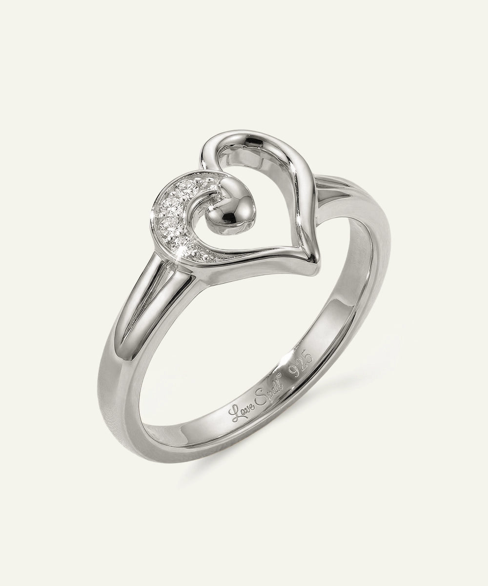 Silver heart-shaped ring with a diamond on a white background