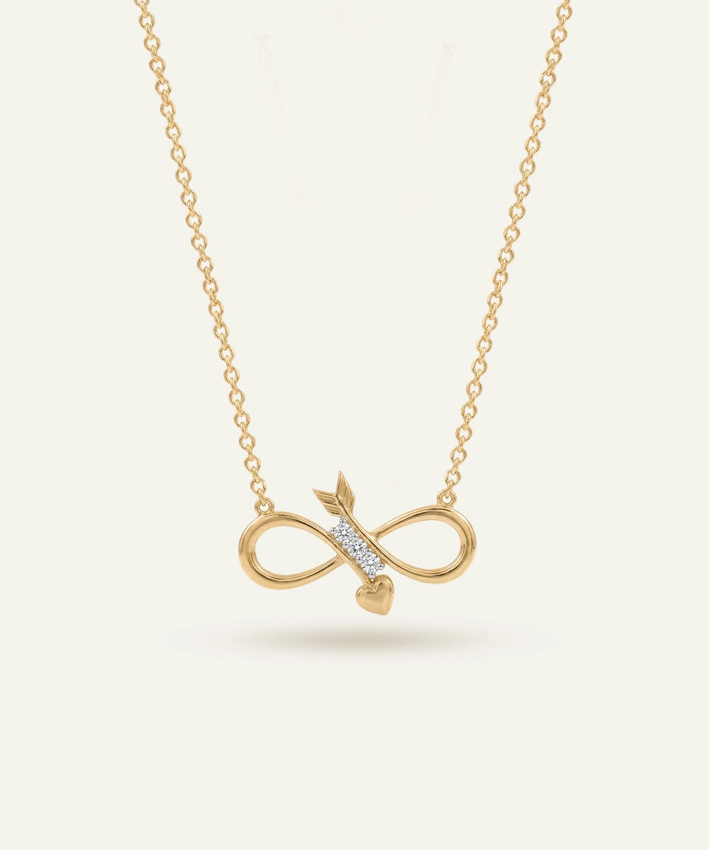 Gold infinity necklace with arrow pendant on a light beige background