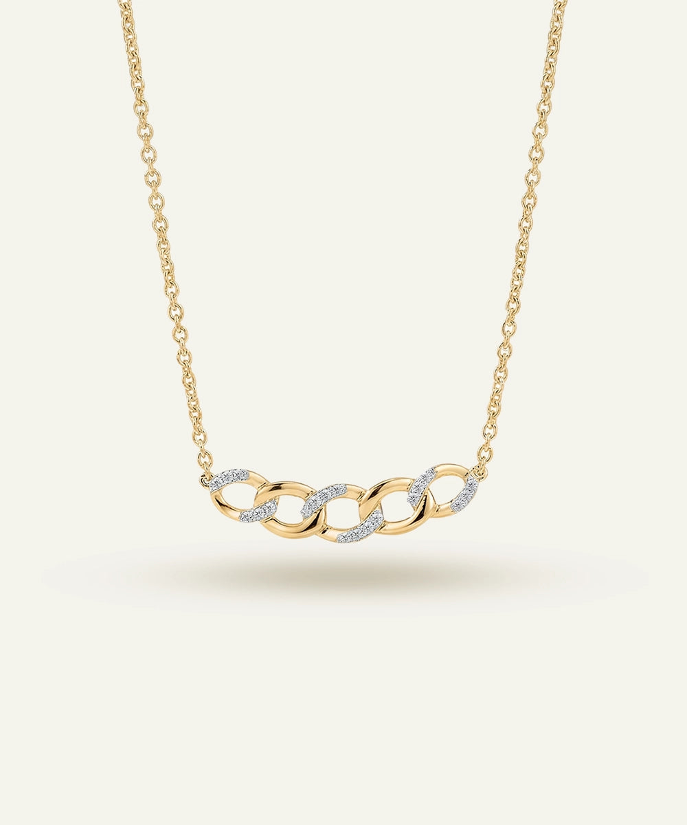 Gold and silver chain necklace on a light beige background