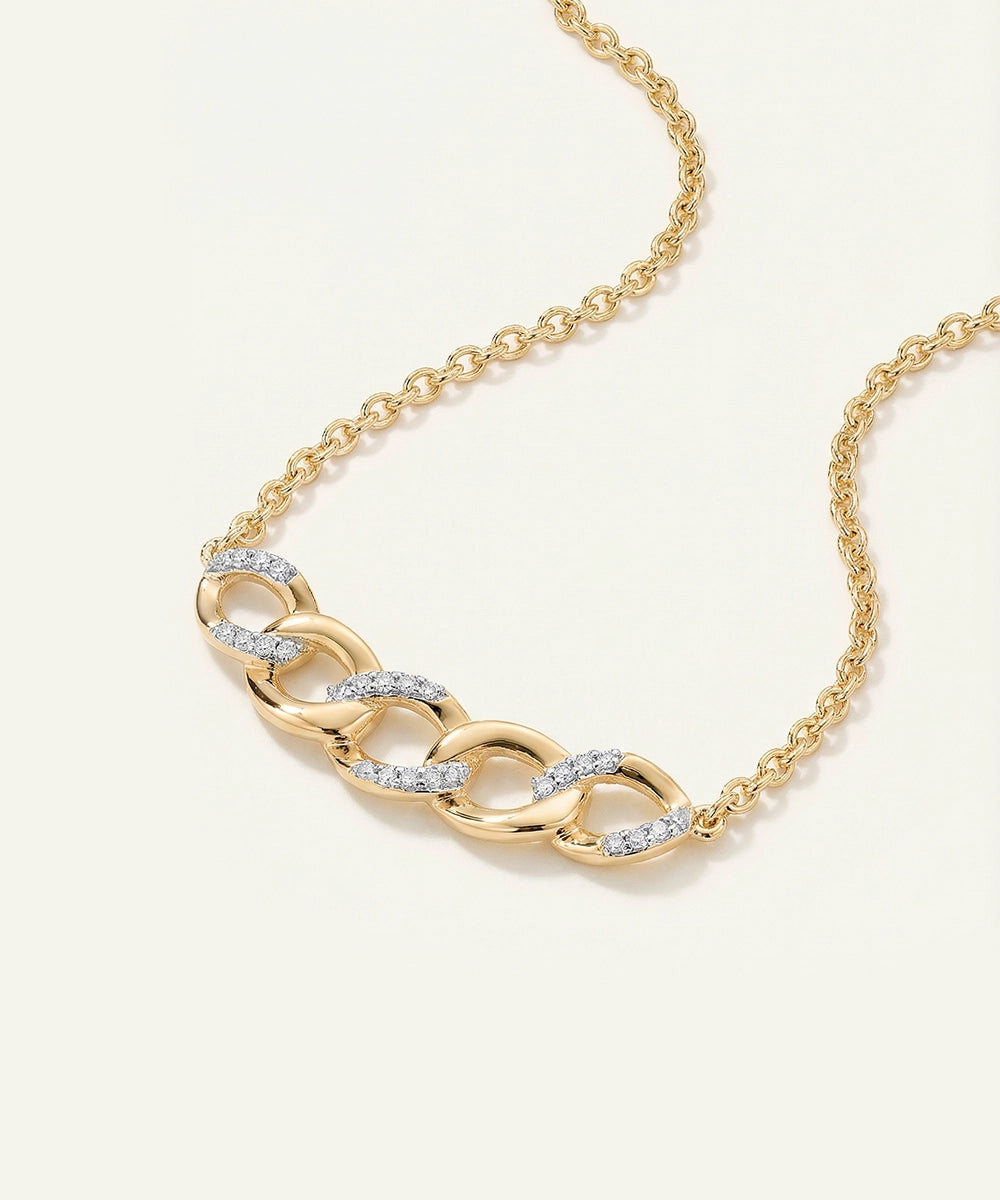 Gold chain necklace with diamond accents on a white background