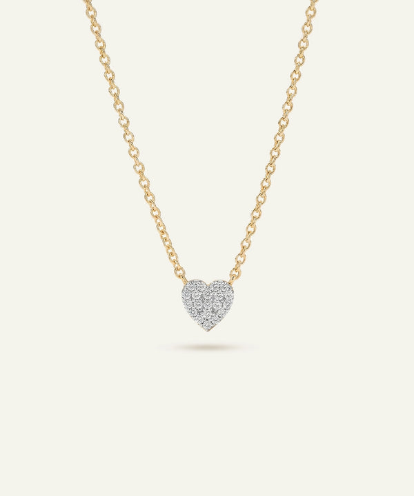 Heart-shaped diamond pendant on a gold chain against a white background