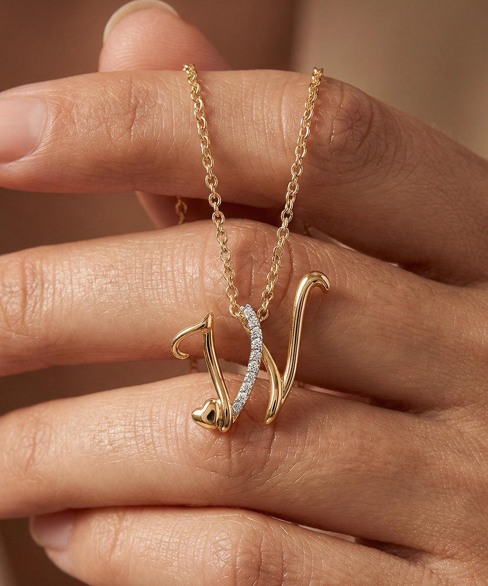 Gold necklace with a unique pendant held by a hand against a neutral background