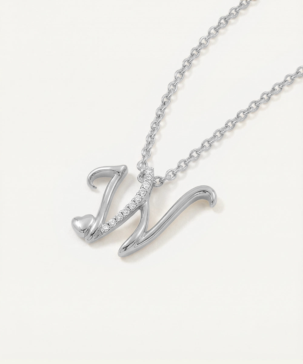 Silver necklace with a 'W' pendant on a light gray background