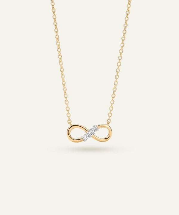 Gold infinity necklace with a diamond on a white background