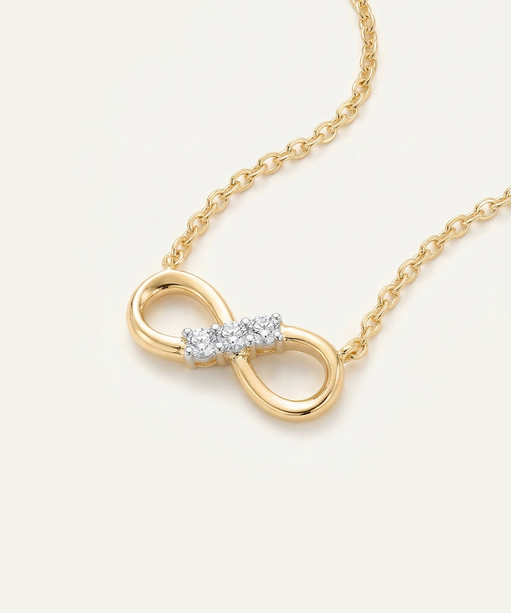 Gold necklace with an infinity symbol pendant on a white background