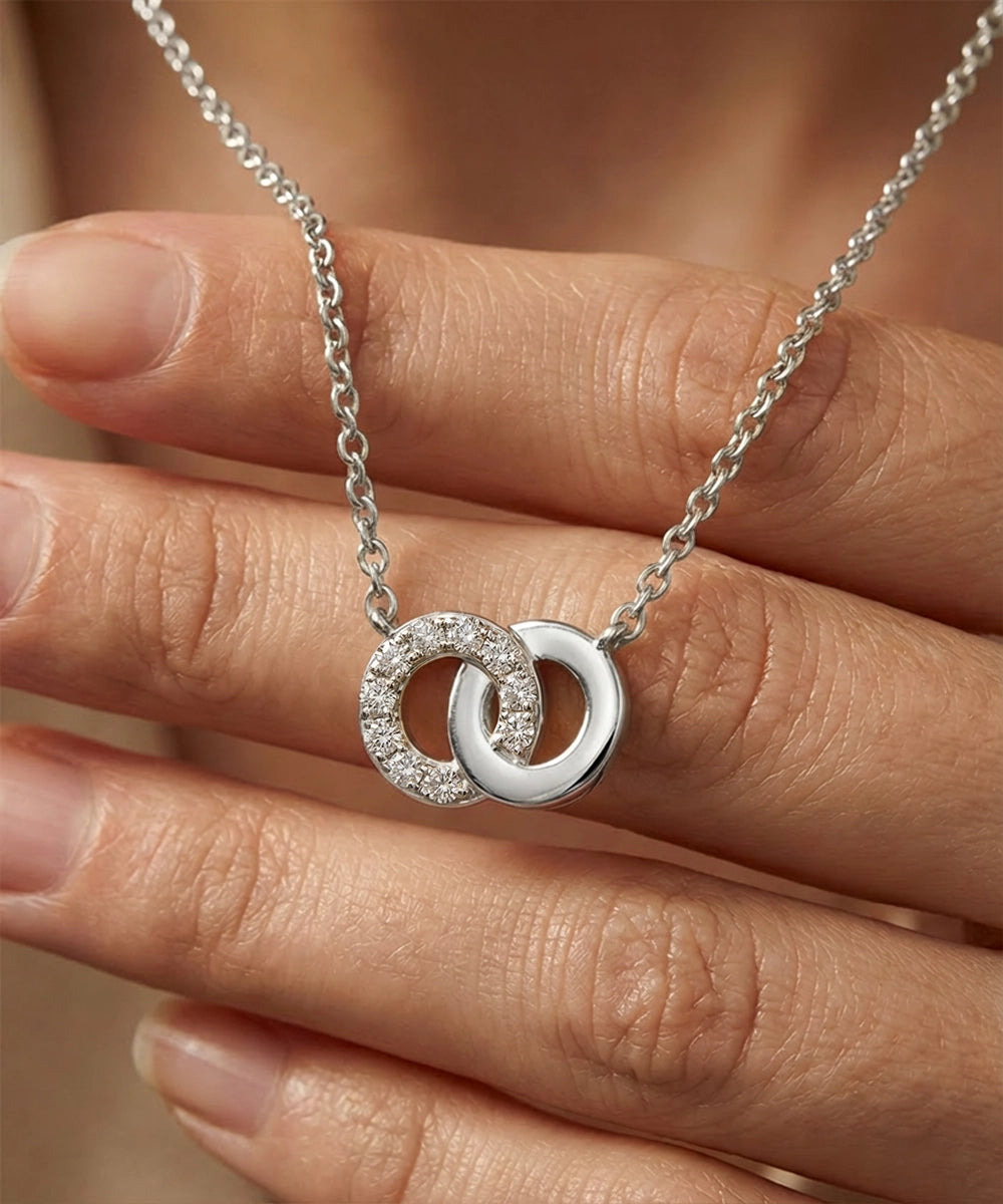 Silver necklace with interlocking rings on a hand