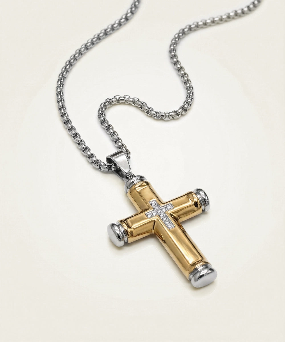 Gold and silver cross pendant on a chain against a white background