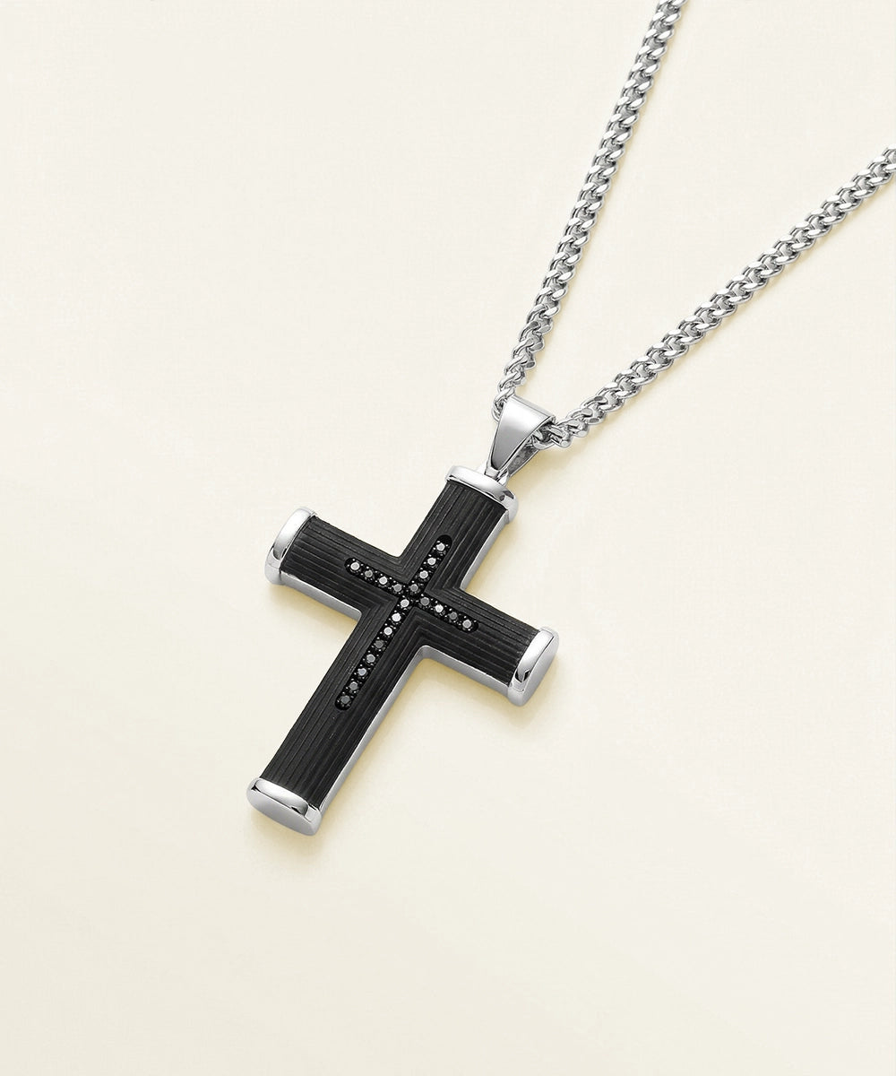 Silver cross pendant necklace on a light beige background