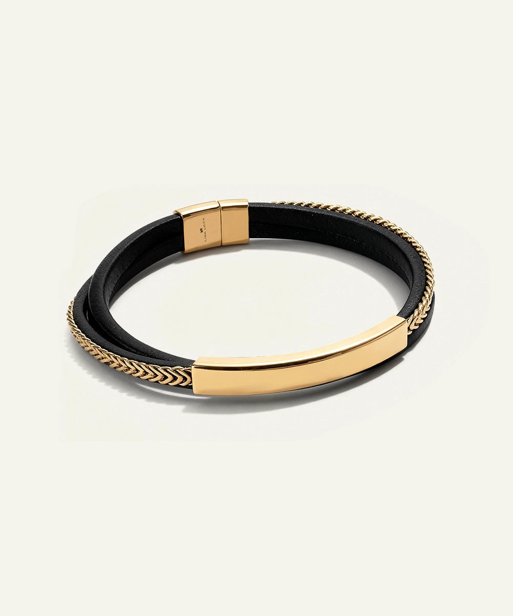 Gold and black bracelet on a light beige background