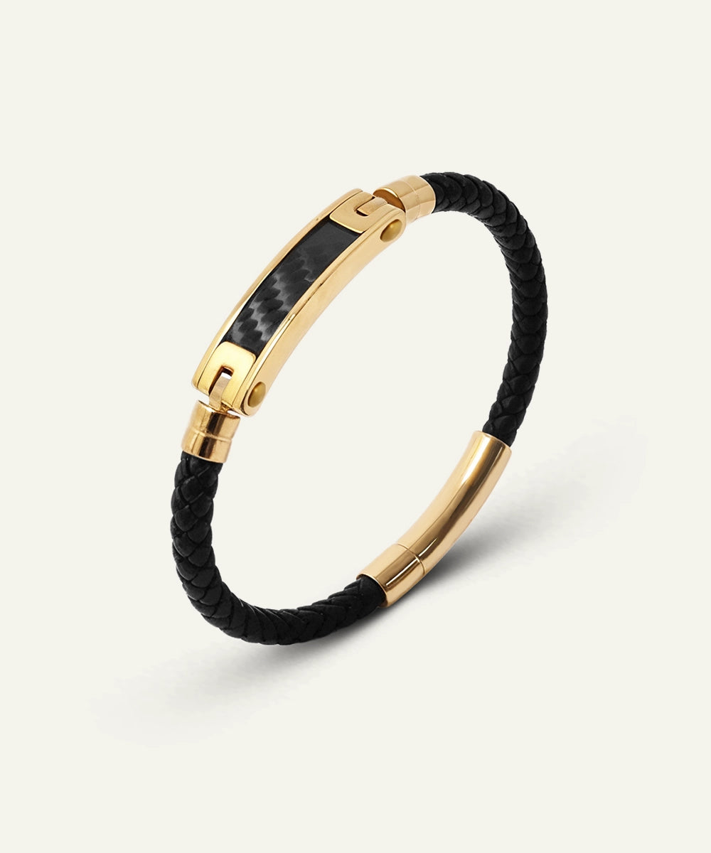 Black braided bracelet with gold clasp on a white background