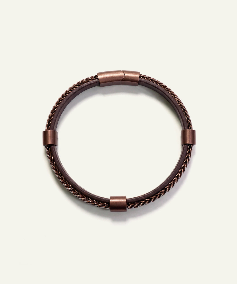 Brown braided leather bracelet on a light beige background
