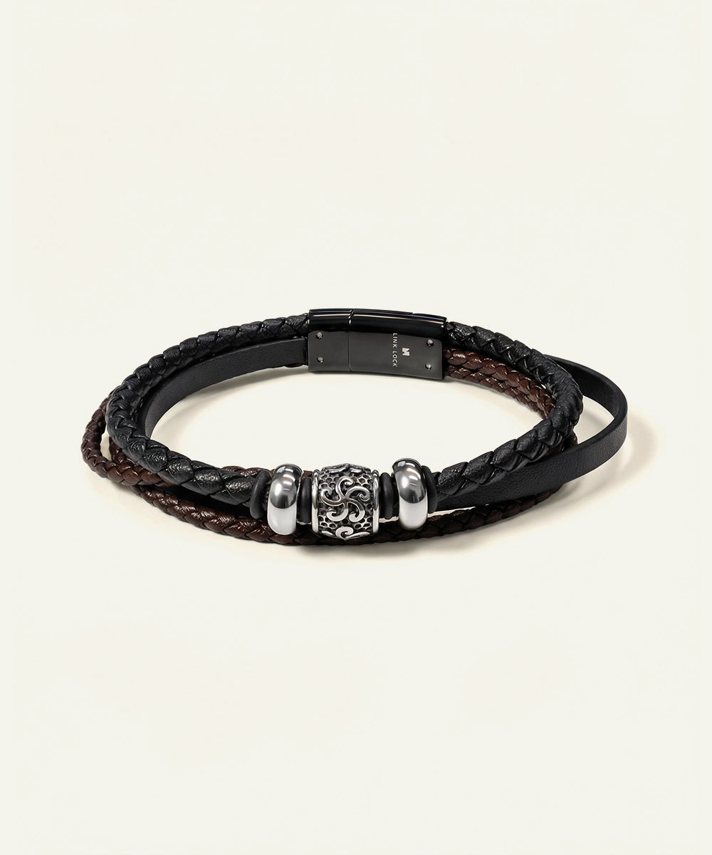 Black braided leather bracelet with silver beads on a light gray background
