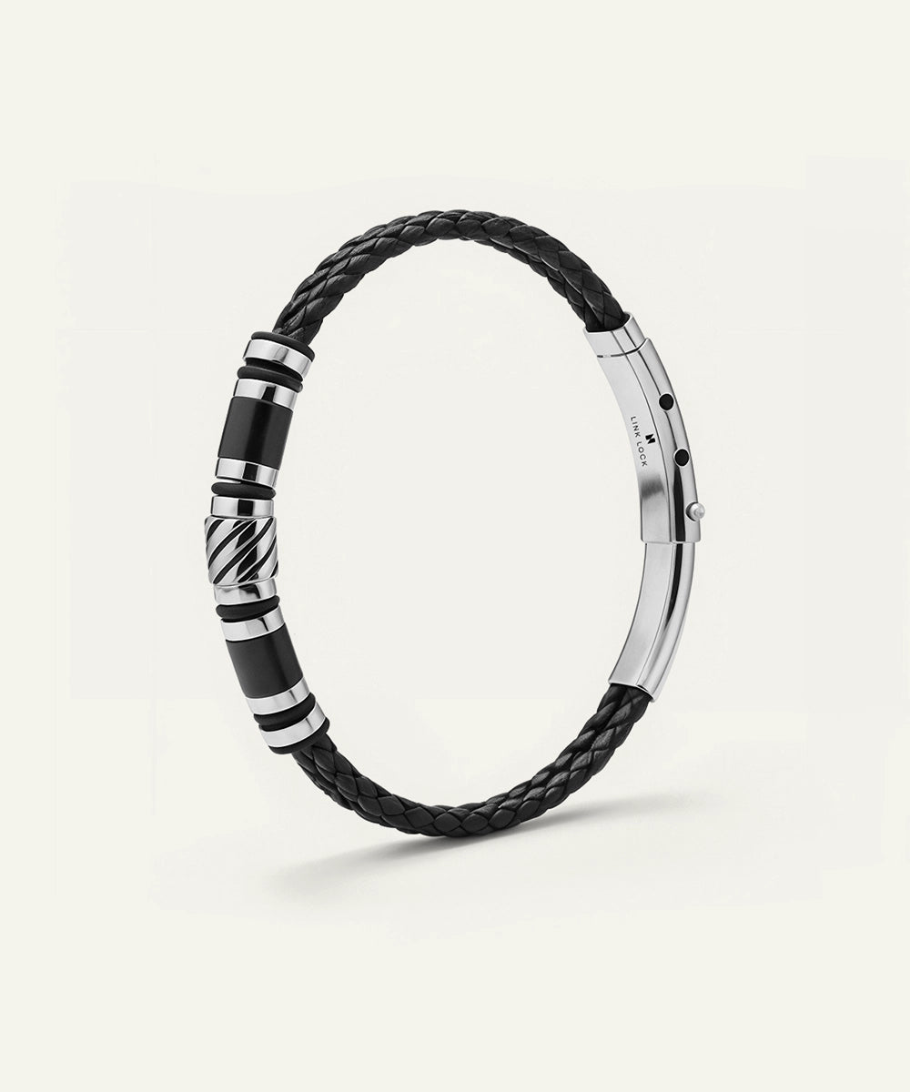 Black braided bracelet with silver accents on a white background