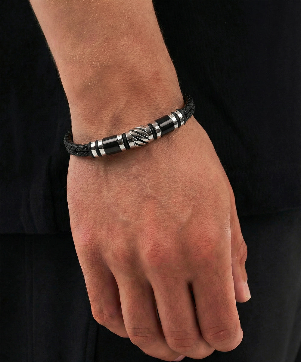 Black and silver beaded bracelet on a wrist against a black background