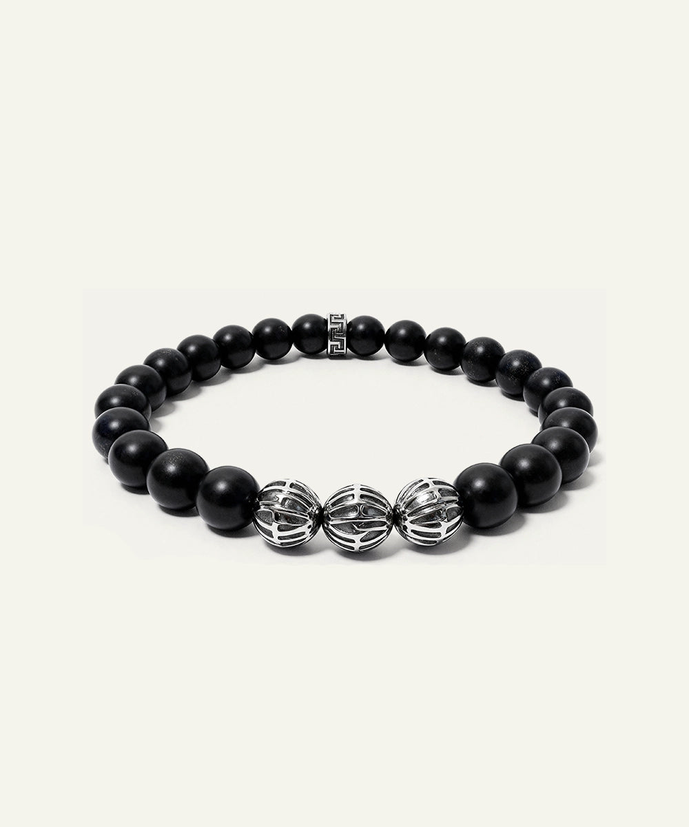 Black beaded bracelet with silver accents on a white background