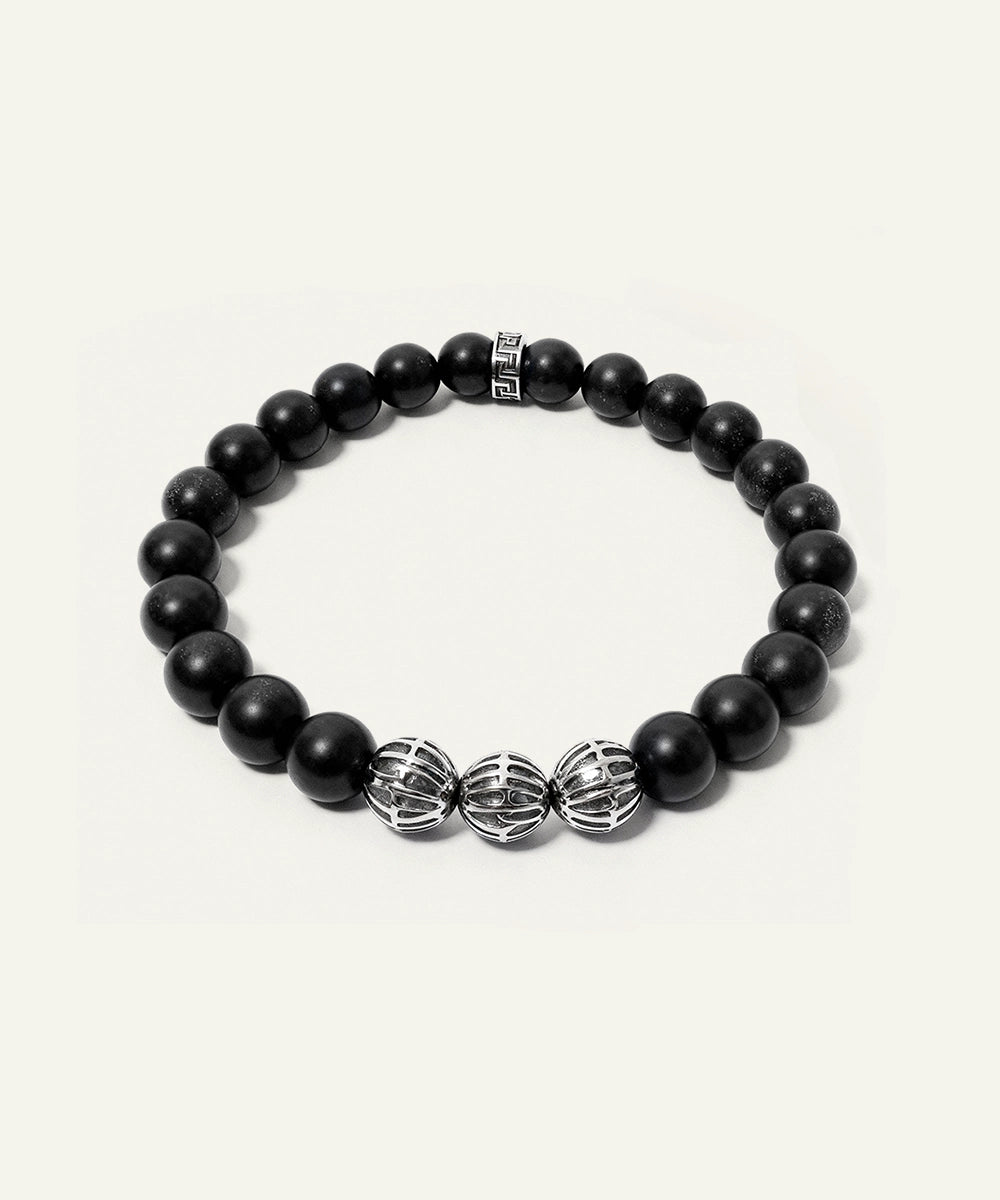 Black beaded bracelet with silver metal beads on a white background