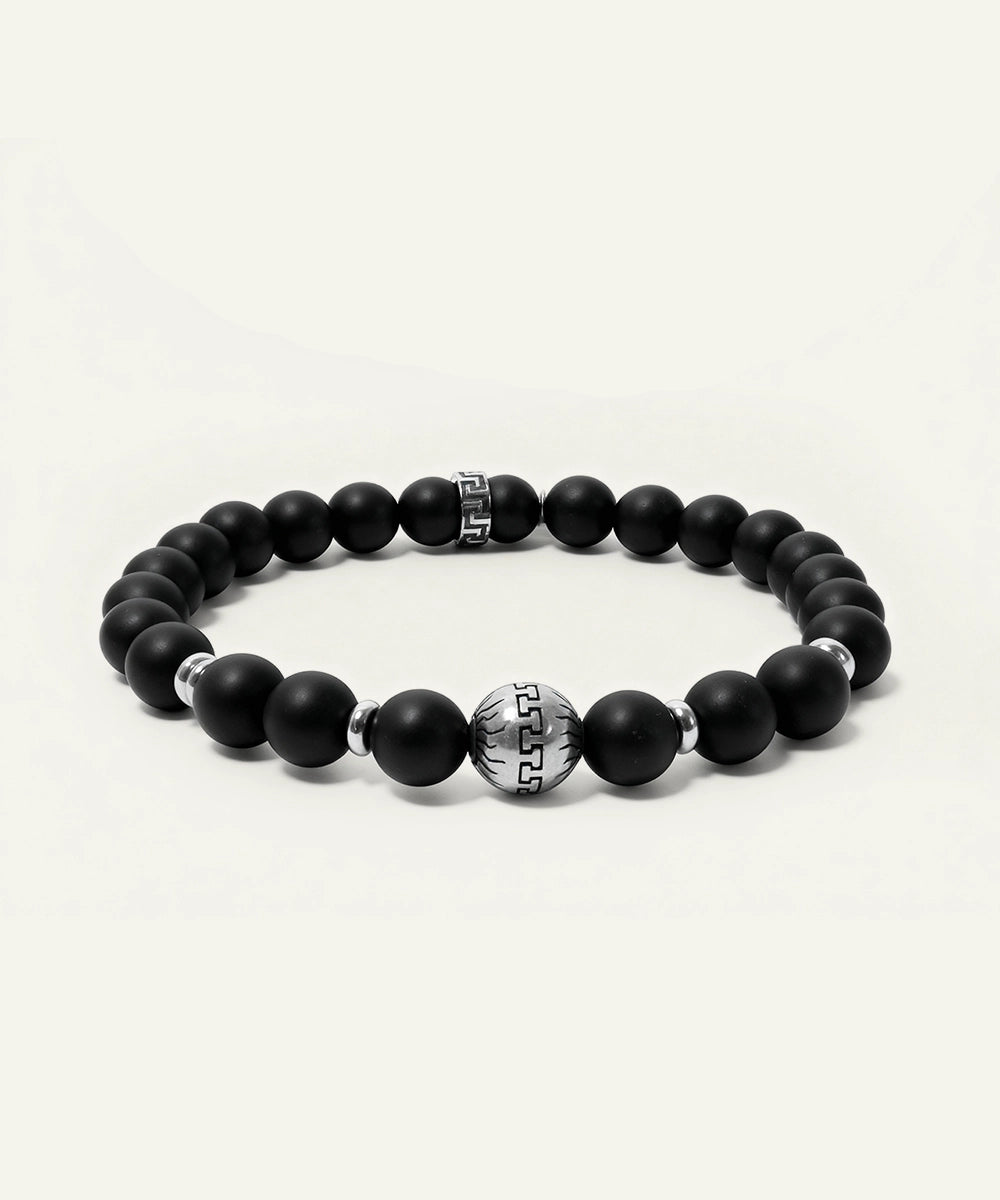 Black beaded bracelet with silver accents on a white background