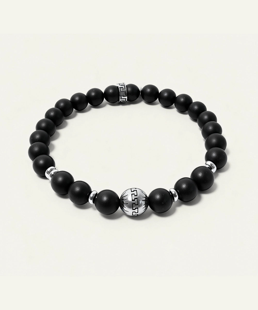 Black beaded bracelet with silver accents on a white background