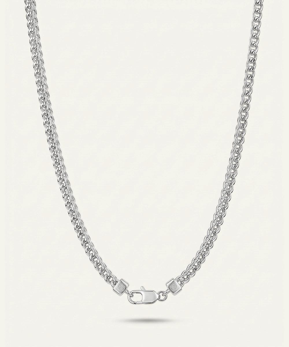 Silver chain necklace on a light gray background