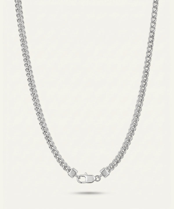 Silver chain necklace on a light gray background