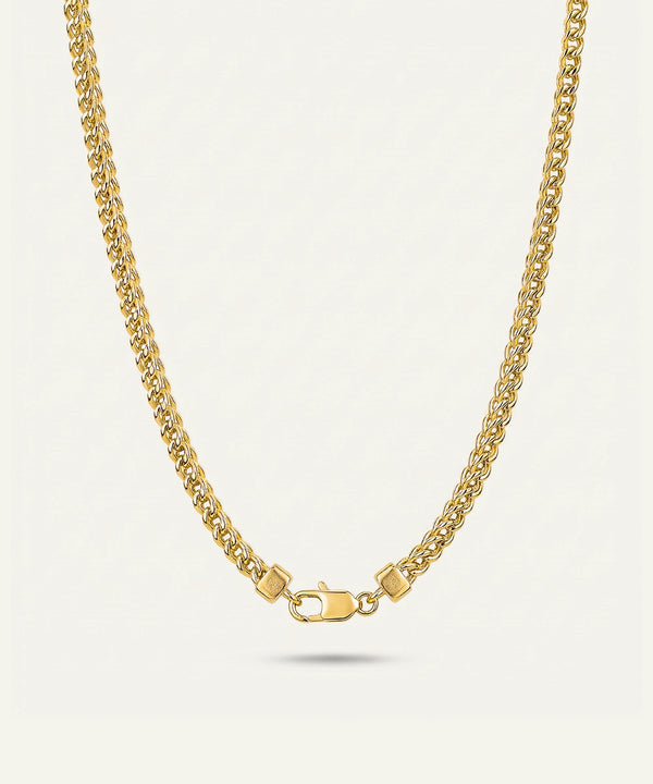 Gold chain necklace on a light gray background