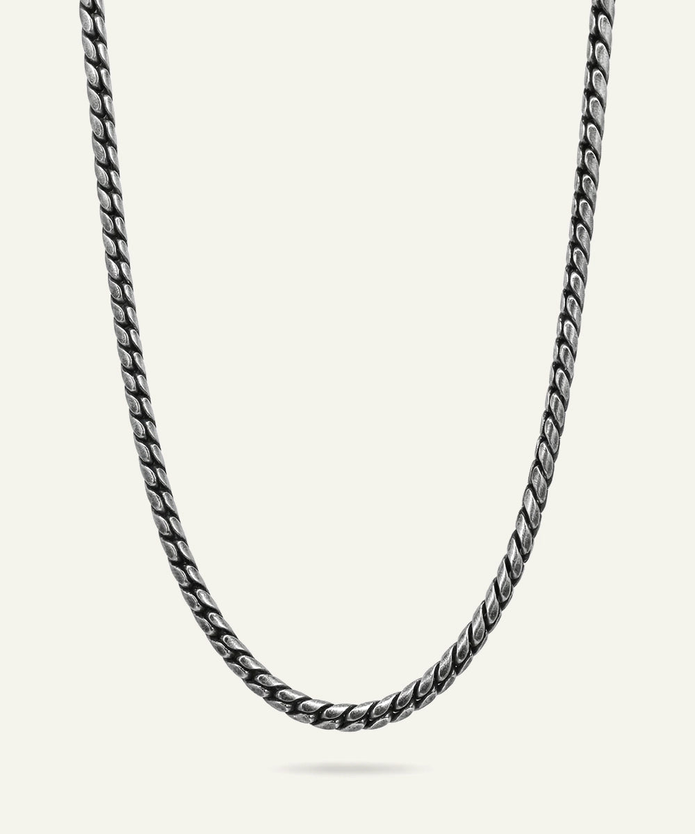 Silver chain necklace on a light gray background