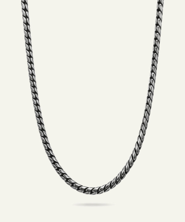 Silver chain necklace on a light gray background