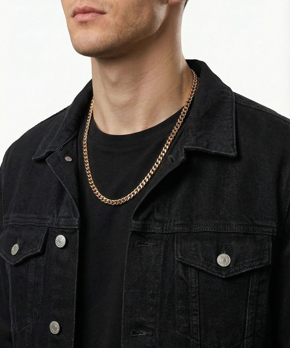 Man wearing a black jacket and gold chain necklace on a white background