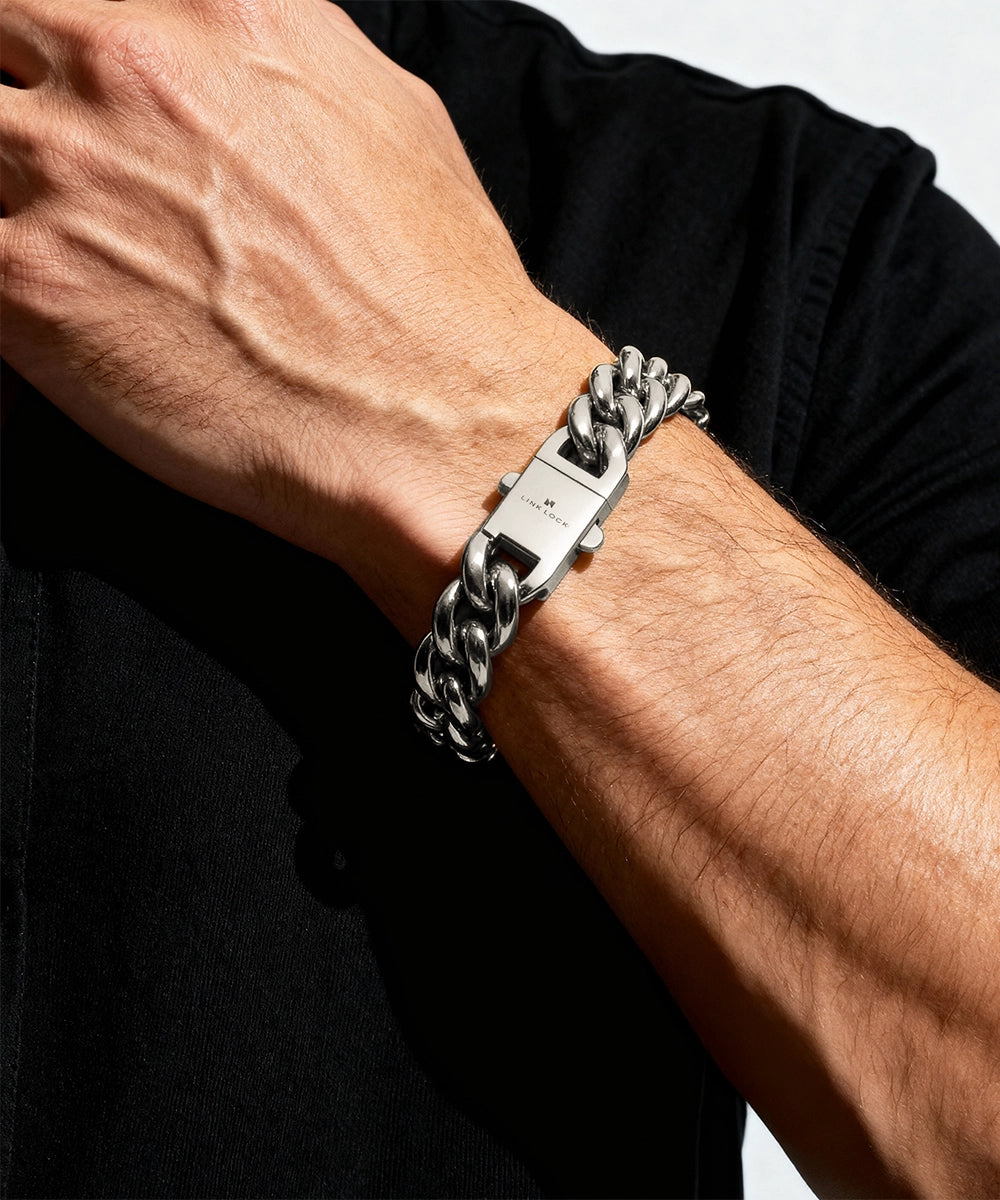 Silver chain bracelet on a person's wrist against a black background