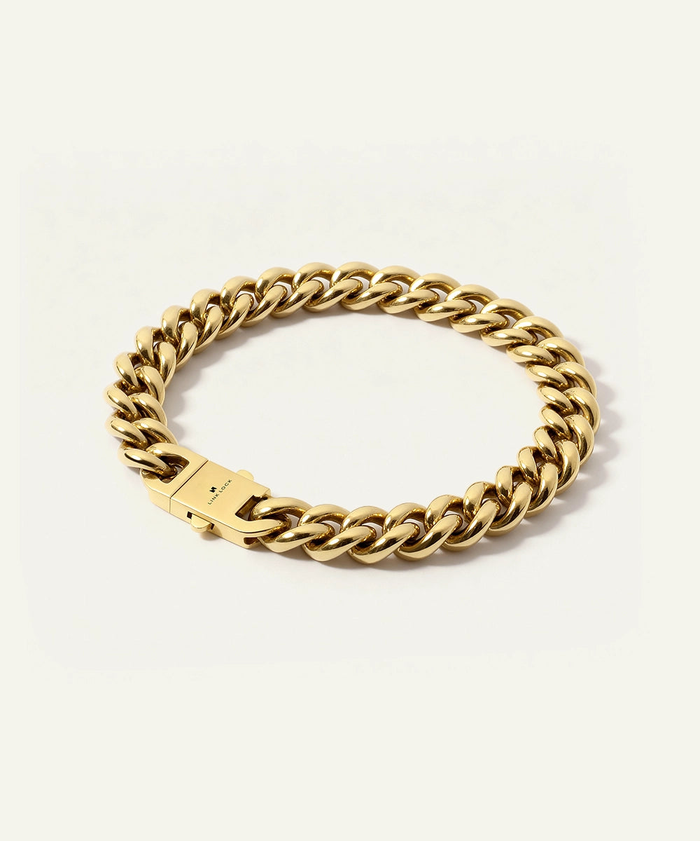Gold chain bracelet on a light beige background