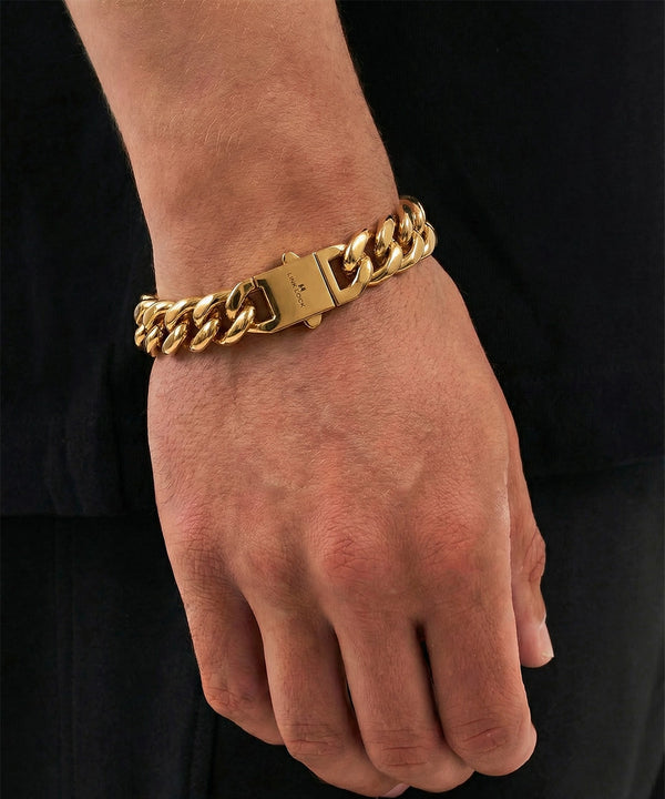 Gold chain bracelet on a person's wrist against a black background