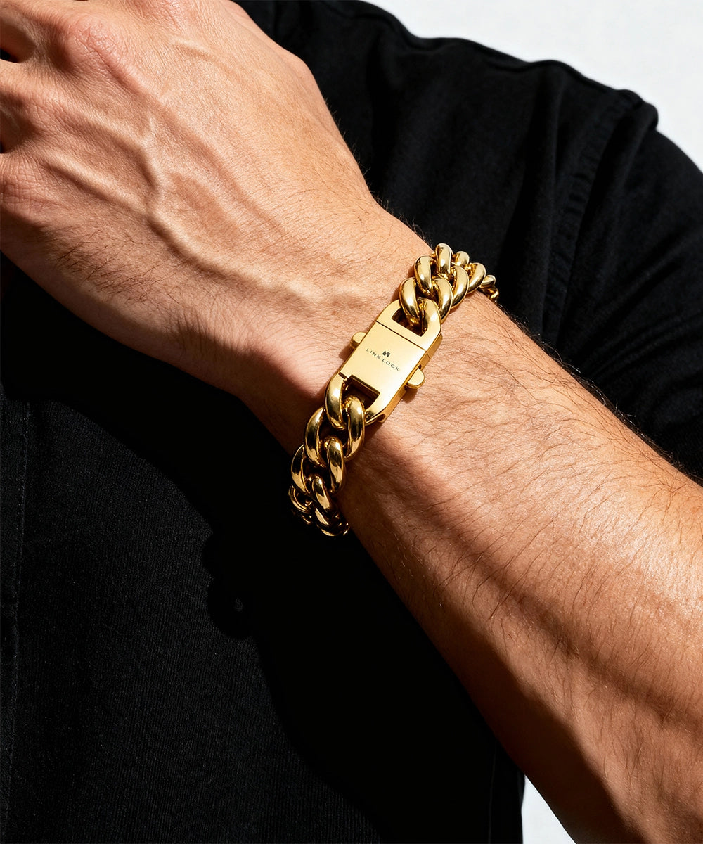 Gold chain bracelet on a wrist with a black background