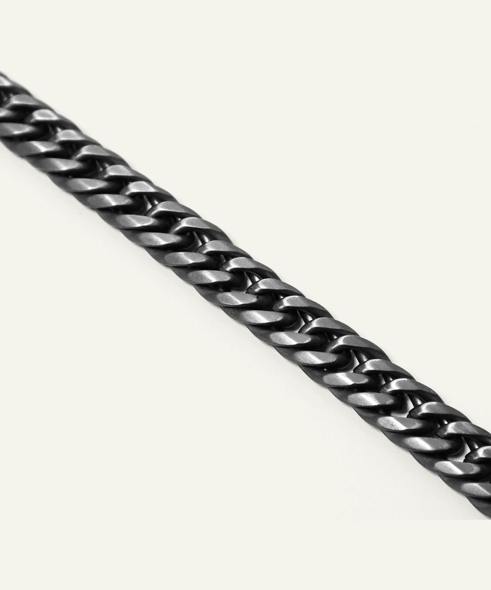 Close-up of a black metal chain on a white background