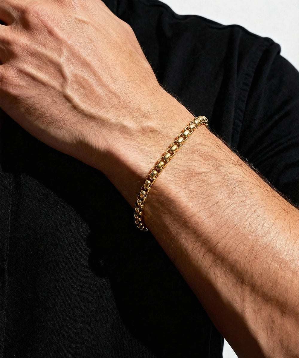 Silver bracelet on a person's wrist with a neutral background