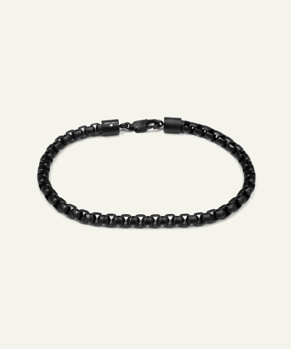 Black beaded bracelet on a light gray background