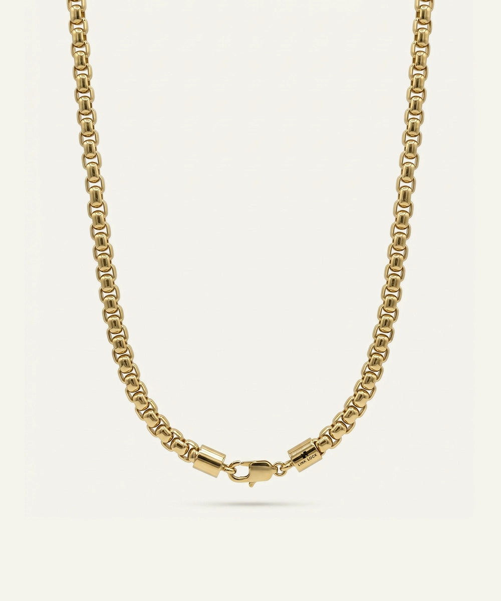 Gold chain necklace on a light beige background
